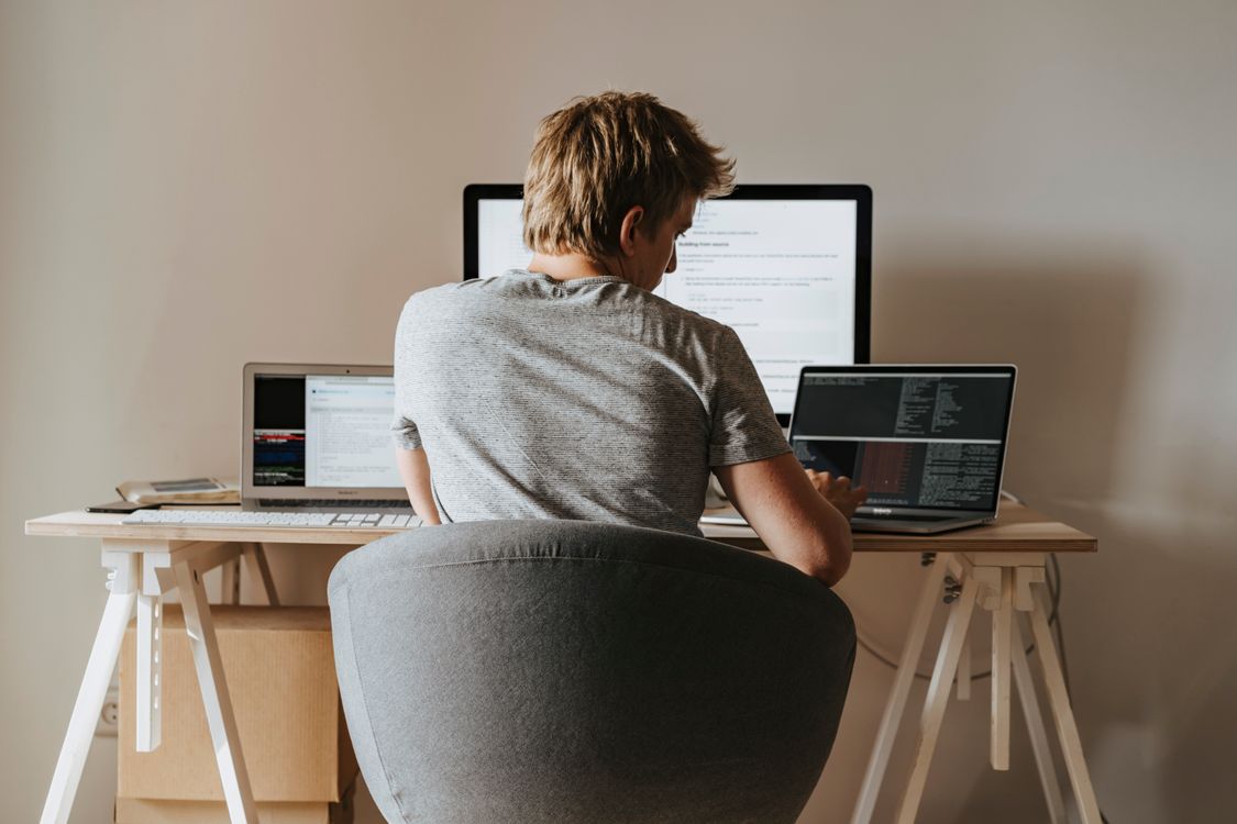 Programmierer arbeitet im Homeoffice mit mehreren Laptops – Angebots-Vorlage für IT-Dienstleister und Webentwickler