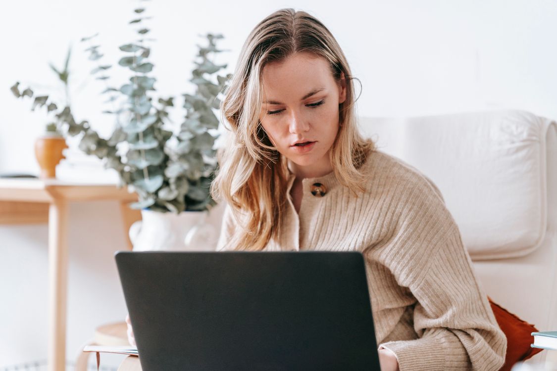 Freelancerin arbeitet konzentriert am Laptop im Homeoffice – Angebots-Muster für Selbstständige und Texter
